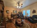Comfortable living room featuring hardwood floors, ceiling fan, and fireplace at 650 N Hawes Rd # 4123, Mesa, AZ 85207
