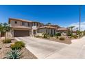 Two-story beige home with a long driveway, tile roof, and desert landscaping at 6870 S Crestview Dr, Gilbert, AZ 85298