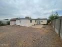 View of the home's exterior and rock-covered backyard, including a small concrete patio at 7139 E Arcadia Cir, Mesa, AZ 85208