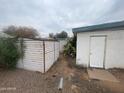 Backyard view of an external storage shed and the home's exterior, yard is rock covered at 7139 E Arcadia Cir, Mesa, AZ 85208