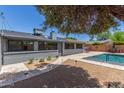 Expansive backyard featuring a pool, lush greenery, and a charming outdoor dining setup at 7727 E 4Th St, Scottsdale, AZ 85251
