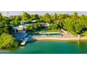 Aerial view of a luxurious backyard featuring a large pool, lush landscaping, and waterfront access at 8312 N Golf Dr, Paradise Valley, AZ 85253