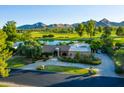 House exterior with golf course and mountain views, mature trees, and a circular driveway at 8312 N Golf Dr, Paradise Valley, AZ 85253