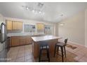 Bright kitchen featuring center island with breakfast bar and tile flooring at 8339 W Bluefield Ave, Peoria, AZ 85382
