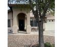 Welcoming home front entrance with an arched entryway, complemented by a quaint seating area and established landscaping at 8981 W Tuckey Ln, Glendale, AZ 85305