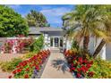Inviting walkway with vibrant flowers leading to a contemporary home entrance with pergola at 10360 N 98Th St, Scottsdale, AZ 85258