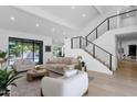 Spacious living room with a modern staircase, neutral tones, and a view of the outdoor pool at 10360 N 98Th St, Scottsdale, AZ 85258