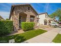 Charming stone accented home featuring a 2 car garage and manicured lawn at 10452 E Natal Ave, Mesa, AZ 85209