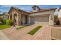 Charming stone accented home featuring a 2 car garage and manicured lawn at 10452 E Natal Ave, Mesa, AZ 85209