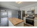 Bright kitchen with stainless steel appliances and an island, connected to a living area at 11210 S Bannock St, Phoenix, AZ 85044
