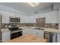 Well-equipped kitchen featuring stainless steel appliances, mosaic backsplash, and ample cabinetry at 11210 S Bannock St, Phoenix, AZ 85044
