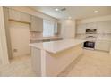 This well-lit kitchen features a large island, quartz countertops, stainless appliances, and sleek gray cabinets at 1122 E Meadowbrook Dr, Casa Grande, AZ 85122