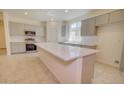 Bright kitchen boasts stainless appliances, grey cabinets, white backsplash, and a quartz countertop island at 1123 E Meadowbrook Dr, Casa Grande, AZ 85122