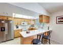 Bright kitchen with white countertops, wood cabinets, and a breakfast bar for casual dining at 1289 Leisure World --, Mesa, AZ 85206