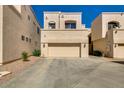 Exterior of townhome featuring a two-car garage, desert landscaping and neutral-colored stucco at 1414 W Coral Reef Dr, Gilbert, AZ 85233