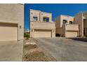 Exterior view of townhomes, each with a two-car garage, neutral stucco, and desert landscaping at 1414 W Coral Reef Dr, Gilbert, AZ 85233