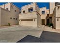 Exterior view of townhome, featuring a two-car garage and neutral stucco at 1414 W Coral Reef Dr, Gilbert, AZ 85233