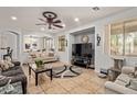 Open-concept living room features a modern ceiling fan, tile floors, and plenty of seating at 15910 W Shangri La Rd, Surprise, AZ 85379