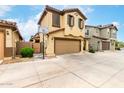 Charming two-story home featuring a two-car garage, tan stucco, and decorative shutters at 16632 W Jenan St, Surprise, AZ 85388