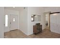 Bright entryway with neutral flooring, white trim, and decorative cabinet with mirror at 17730 E Brooks Farm Rd, Gilbert, AZ 85298