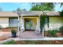 Inviting front entrance with a pergola, brick patio, and a cozy seating area at 17730 E Brooks Farm Rd, Gilbert, AZ 85298