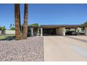 Charming home exterior featuring mature landscaping and a spacious covered carport for convenient parking at 1982 E Oxford Dr, Tempe, AZ 85283