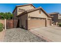 Side view of a 3-car garage with a private gated entrance on a paved driveway at 26249 N 68Th Ln, Peoria, AZ 85383