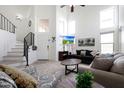 Bright living room features soaring ceilings, tile floors, and stairs with black iron railing at 31227 N 45Th St, Cave Creek, AZ 85331