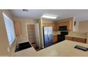 Functional kitchen with stainless steel appliances, light wood cabinets, and pantry at 3405 W La Salle St, Phoenix, AZ 85041