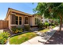 Inviting home showcasing a cozy front porch, lush landscaping, and convenient sidewalk access at 3477 E Sheffield Rd, Gilbert, AZ 85296