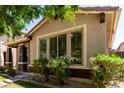 Beautiful home highlighting large windows, mature greenery, and a welcoming entrance at 3477 E Sheffield Rd, Gilbert, AZ 85296