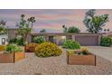 Charming home with desert landscaping and colorful flowering bushes in planter boxes under a colorful sky at 3823 E Poinsettia Dr, Phoenix, AZ 85028