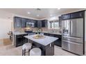 Modern kitchen features stainless appliances, granite counters, and a large center island with barstool seating at 3823 E Poinsettia Dr, Phoenix, AZ 85028