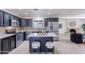 Modern kitchen boasts stainless appliances, granite counters, large center island, and adjacent fireplace at 3823 E Poinsettia Dr, Phoenix, AZ 85028