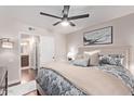 Comfortable bedroom featuring a ceiling fan, decorative pillows, and a glimpse of an en-suite bathroom at 4120 N 78Th St # 216, Scottsdale, AZ 85251