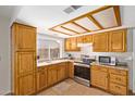 Efficient kitchen featuring warm wood cabinets, stainless steel appliances, and a bright window at 4629 N 78Th Dr, Phoenix, AZ 85033