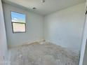 Clean bedroom with bright white walls, natural light from a large window, and unfinished flooring at 46819 W Cansados Rd, Maricopa, AZ 85139