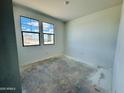 Unfinished bedroom with ample natural light, freshly painted white walls, and unfinished flooring at 46819 W Cansados Rd, Maricopa, AZ 85139