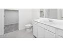 Bright bathroom featuring a single sink vanity, toilet, and a shower over tub with glass doors at 5761 E Iris Dr, Florence, AZ 85132