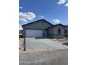 Newly constructed single-story home with a spacious driveway leading to an attached two-car garage at 5761 E Iris Dr, Florence, AZ 85132