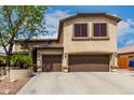 Two story home featuring a three car garage, desert landscaping and a mature shade tree at 5910 W Blue Sky Dr, Phoenix, AZ 85083