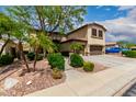 Exterior view of a two story home with a three car garage, desert landscaping and mature trees at 5910 W Blue Sky Dr, Phoenix, AZ 85083