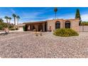 Well-maintained brick home with arched entryway, low maintenance landscaping, and a welcoming facade at 6622 E Voltaire Ave, Scottsdale, AZ 85254