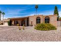 Single-story brick home featuring arched entryway, desert landscaping, and a two-car garage at 6622 E Voltaire Ave, Scottsdale, AZ 85254