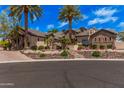 Stunning home featuring desert landscaping, mature palm trees, and a beautiful stone and stucco facade at 7018 E Ingram St, Mesa, AZ 85207