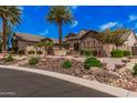 Stunning home featuring desert landscaping, mature palm trees, and a beautiful stone and stucco facade at 7018 E Ingram St, Mesa, AZ 85207
