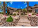 Beautiful desert landscaping leads up to this property, featuring large palm trees and decorative rock at 7018 E Ingram St, Mesa, AZ 85207