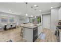 Open concept kitchen with a center island, bar stool seating, and wood floors; dining area and living area visible at 7732 S 23Rd St, Phoenix, AZ 85042