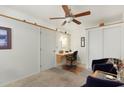 Neutral bedroom with carpet, ceiling fan, and built-in desk adjacent to the closet at 8255 E Kiva Ave # 422, Mesa, AZ 85209