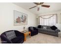 Comfortable living room featuring a ceiling fan, neutral carpet and a large painting at 8255 E Kiva Ave # 422, Mesa, AZ 85209